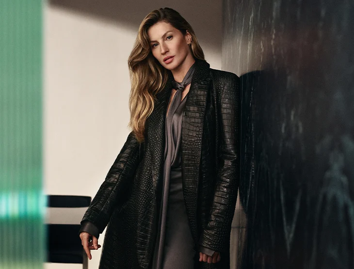 Giselle Bündchen posiert vor einem dunklen Hintergrund und trägt eine schwarze Lederjacke (Foto)